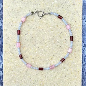 Macro view of natural stone beaded choker featuring pink, blue beads and silver OT clasp