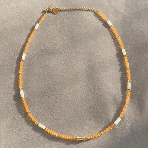 Detailed view of handcrafted orange crystal and white shell tube bead choker necklace