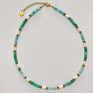 Detailed view of natural stone beaded necklace with green and white beads and gold accents.