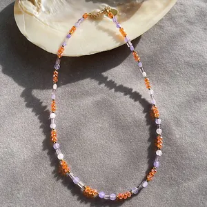 Detail view of natural stone beaded necklace with orange and purple beads