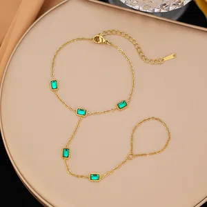 Dettaglio del bracciale a mano in acciaio inossidabile dorato con cristalli verdi