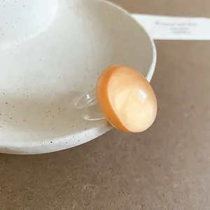 Minimalist peach resin ring with a smooth oval geometric design in a vibrant dopamine style