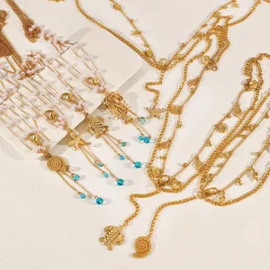 Close-up of multilayer gold body chain featuring marine starfish and lobster pendants