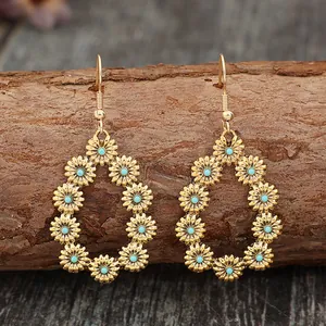 Gros plan détaillé de boucles d'oreilles vintage dorées avec fleurs turquoise