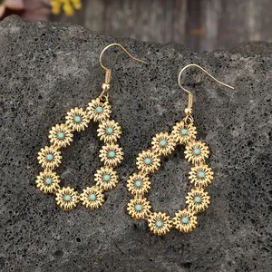 Détail de boucles d'oreilles pendantes vintage dorées avec fleurs en turquoise