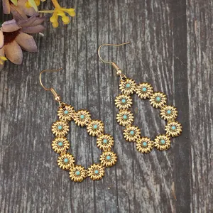 Vue détaillée de boucles d'oreilles larmes avec fleurs dorées et centres turquoise.