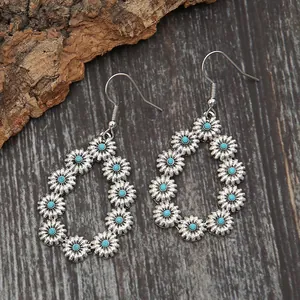 Gros plan de boucles d'oreilles bohèmes en argent avec des fleurs turquoises