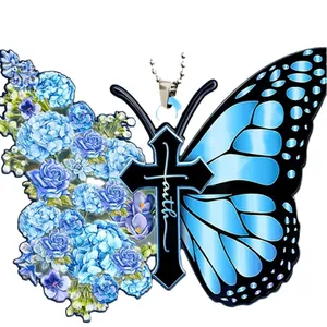 Detailed view of butterfly cross pendant with blue flowers and 'faith' inscription.