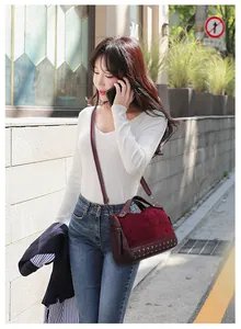 Vista dettagliata di una borsa bordeaux elegante con borchie indossata da una modella