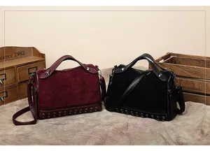 Dettaglio borse da motociclista vintage con borchie in pelle scamosciata bordeaux e nera