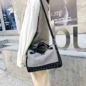 Dettaglio borsa a mano stile biker opaca alla moda con borchie e tracolla regolabile.
