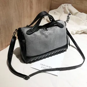 Vista dettagliata della borsa con borchie in camoscio grigio e pelle nera