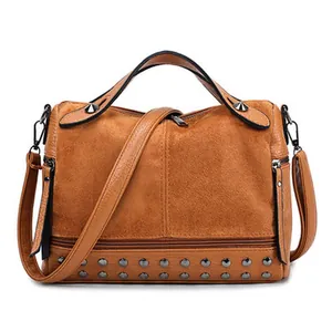 Borsa marrone in pelle scamosciata con borchie metalliche e tracolla regolabile