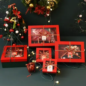Festive red and green Christmas gift boxes with clear windows and striped ribbon bows.