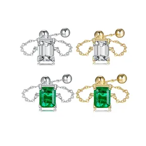 Close-up of elegant emerald-cut gemstone rings featuring minimalist metal chain bands