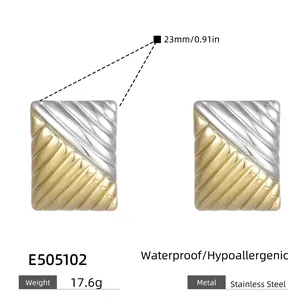 Detail view of two-tone stainless steel square earrings with ribbed grid texture