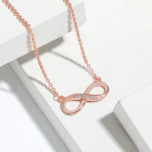 Detailed view of a rose gold infinity symbol necklace set with sparkling white stones