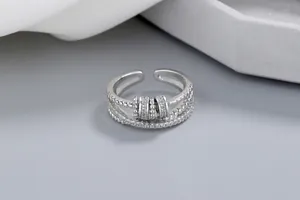 Gros plan d'une bague anti-stress en argent avec double anneau et zircons brillants