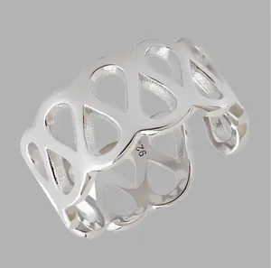 Vue détaillée d'une large bague évidée en argent au design géométrique épuré