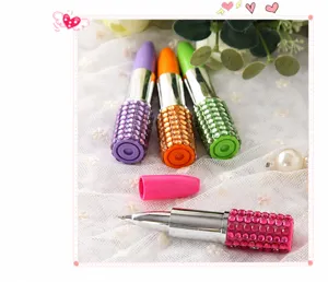 Detalle de lindos bolígrafos con forma de lápiz labial y brillantes detalles de diamantes