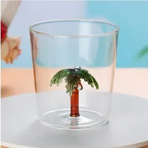 Detailed macro view showing the 3D glass palm tree sculpture inside a clear drink cup