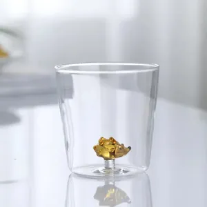 Close-up detail of a 3D amber hedgehog animal figurine inside a transparent glass drink cup