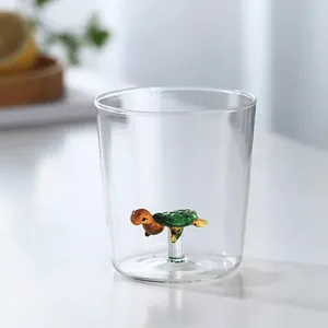 Detail of transparent glass cup with a cute 3D green turtle figure inside at the base
