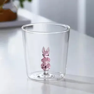 Macro detail showing a clear glass drinking cup with a pink 3D bunny figurine inside