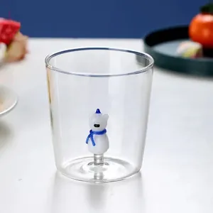 Close-up of clear glass cup with 3D cartoon animal figurine at bottom