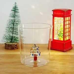 Detail of a transparent glass cup with a festive 3D miniature Christmas tree inside