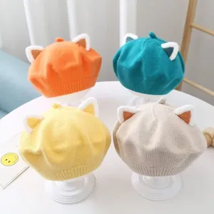 Close-up of kids' knitted berets with plush cat ears in four vibrant colors for winter.