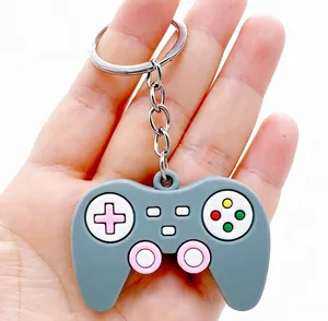 Detail view of a soft rubber game controller keychain with colorful buttons held in hand