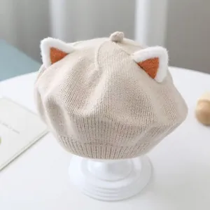 Close-up of baby knitted beret hat with cute cat ears in beige