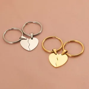 Close-up of split heart-shaped couple keychains in silver and gold stainless steel
