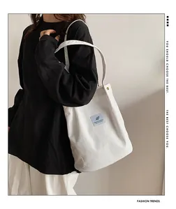Borsa a spalla in velluto a coste bianco indossata dal modello, mostra capienza e consistenza.