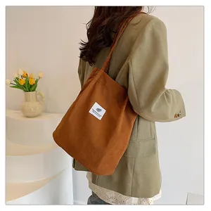 Grande borsa a tracolla in velluto a coste marrone da donna con blazer verde oliva