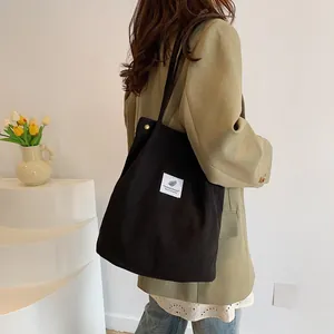 Vista dettagliata di un'elegante borsa a tracolla in velluto nero indossata da una modella