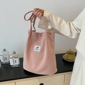 Dettaglio borsa tote in velluto rosa con texture morbida e patch dal design chic