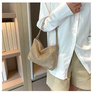 Primer plano de un bolso de mano de strass dorado brillante para ropa de noche.