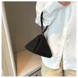 Sofisticado bolso de mano triangular con pedrería negra para la noche, vista macro detallada