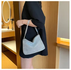 Vista detallada del bolso de diamantes de imitación plateados llevado por una modelo en negro.