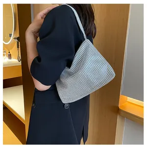 Detalle de un elegante bolso de hombro de malla de pedrería plateada usado por una modelo