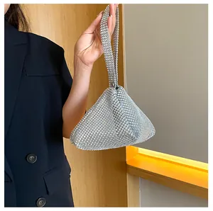 Vista detallada de un bolso de mano triangular de strass plateado con malla brillante.