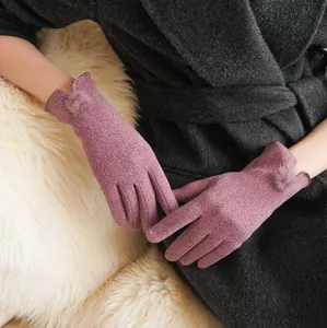 Detailweergave van elegante paarse winterhandschoenen met zachte bontpomponversieringen