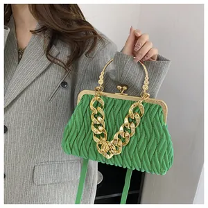Dettaglio borsa a mano verde plissettata con catena dorata e chiusura a scatto vintage