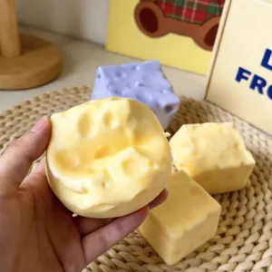 Dettaglio di un realistico squishy a forma di formaggio giallo tenuto in mano anti-stress