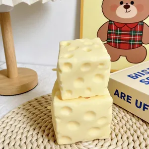 Giocattolo antistress squishy a forma di cubo di formaggio su un sottobicchiere.