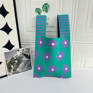 Detailed macro view of the green and purple floral pattern on this knitted vest tote bag