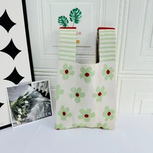 Detail view of the green floral pattern and knitted texture on a large capacity tote bag