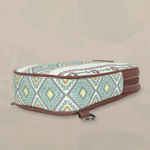 Close-up detail view of canvas waist bag with geometric patterns and leather trim